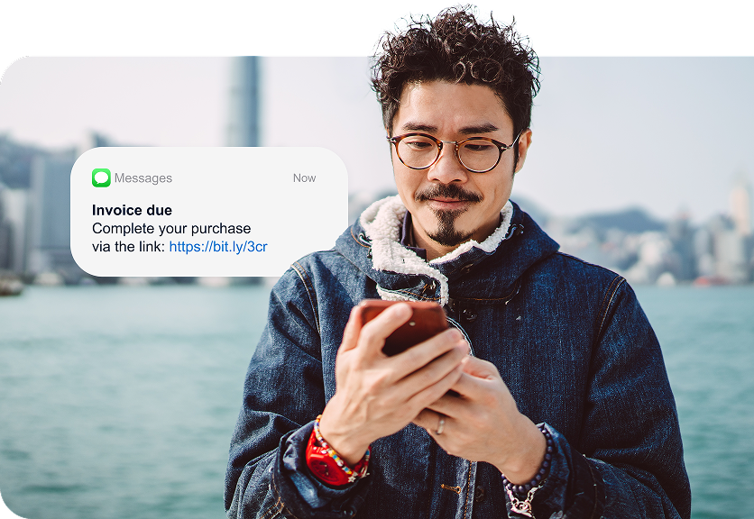 A man holds a mobile phone in his hands and a graphic element shows he’s seeing an invoice due notification.