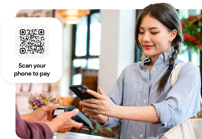 A customer scanning a QR code to pay with her phone at a retail store.