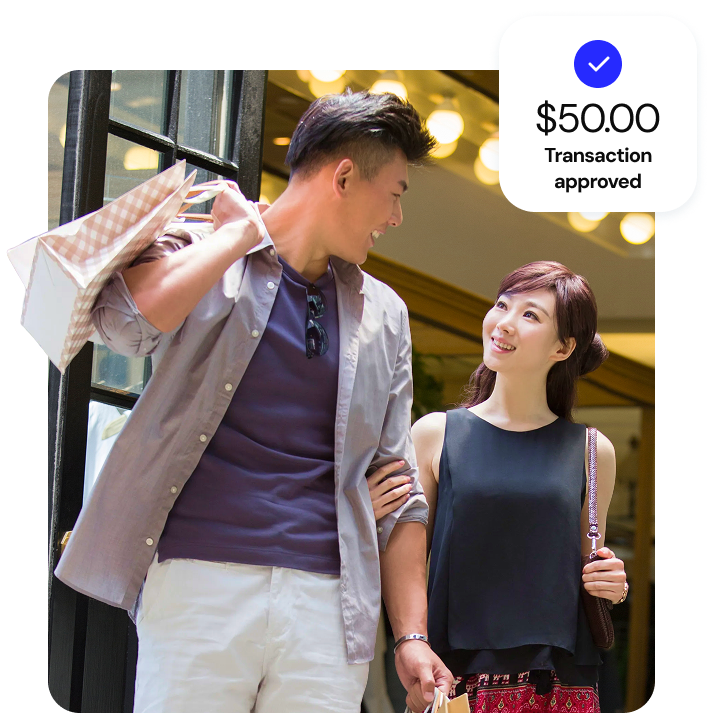Two smiling retail customers looking at each other and walking out of a storefront 