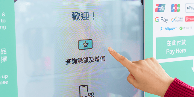 一隻手指向自助終端觸控螢幕,瀏覽活動資訊、門票及付款方式 一站掌握資訊與支付 — 讓體驗更簡單,轉化更直接。