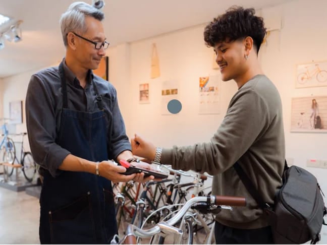 Customer paying with a smartwatch at a bicycle shop card reader.