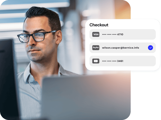 A man with glasses makes a payment on his computer. A pop up shows a secure credit card checkout.