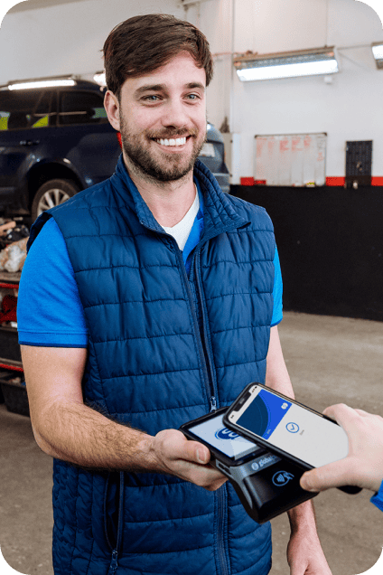 Customer waves a phone over a Global Payments POS, while a car salesman takes a secure payment