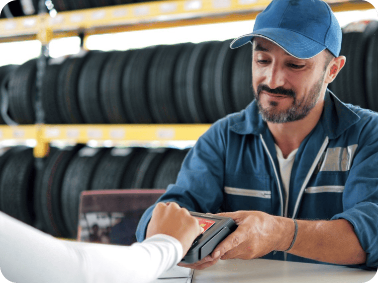 Tire salesperson taking a card payment on a POS