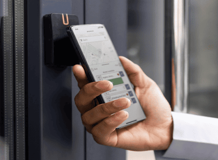 A person using a cell phone application to access a building on a college campus.
