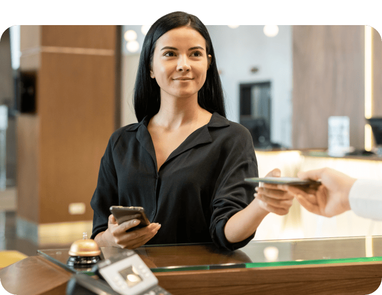 Une femme remet son passeport à la réception d'un hôtel lors de l'enregistrement.