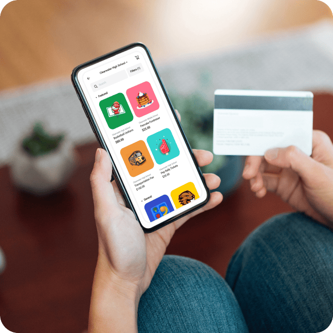 A person holds a smartphone displaying an online shopping app and a credit card, preparing to make a purchase.