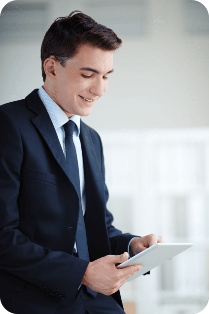 Professional man in a suit looking down at a white tablet screen.