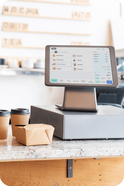 Caisse enregistreuse tactile sur le comptoir d'un café, avec commandes à emporter.