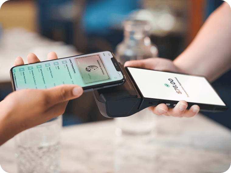 Customer tapping an iPhone on a POS terminal to complete a $76.00 contactless payment.