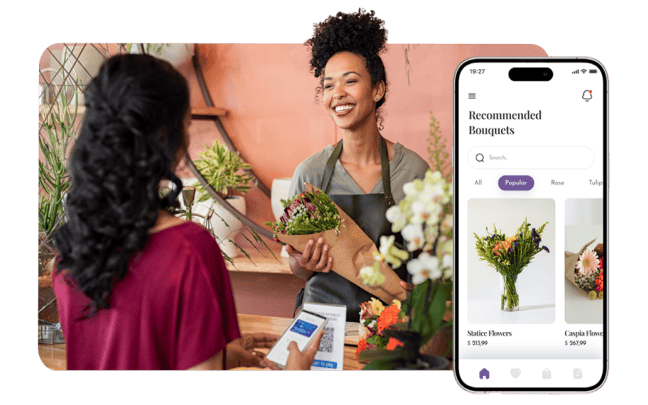 Smiling flower shop employee checks out a customer paying with a digital wallet. A phone shows a flower shop ecommerce site with “Recommended Products” on screen.
