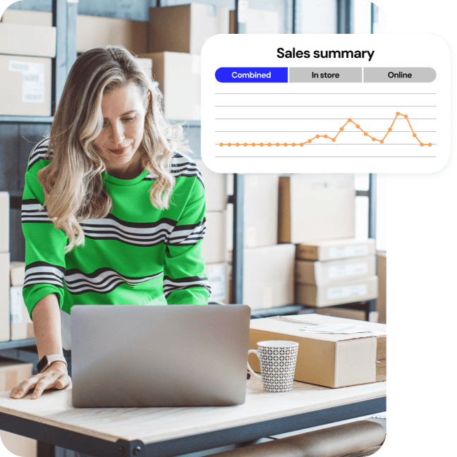 Small business owner in a stock room smiling at her laptop. A “Sales summary” screen with a sales chart is popping out.