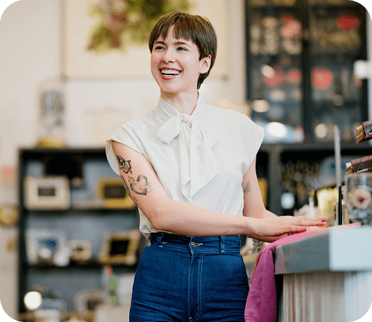 Small business employee smiling and looking off camera in their shop