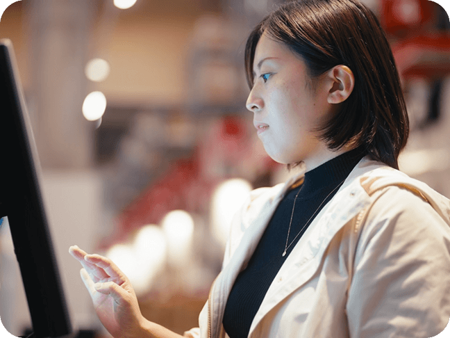 Une femme passe sa commande à une borne interactive.