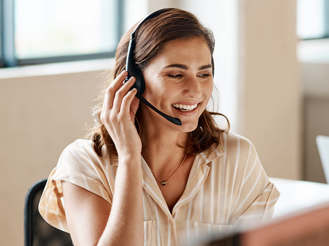 Smiling customer service representative wearing a headset.