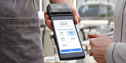 Close up of a man making a payment to a handleld POS device