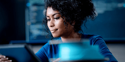 Woman in high tech office enviroment looking at tablet screen