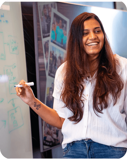 Smiling woman standing at whiteboard in office setting 