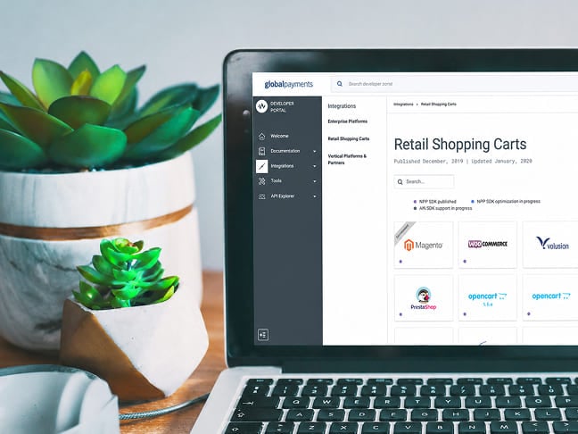 Global Payments portal on a laptop displaying retail shopping cart platform integrations