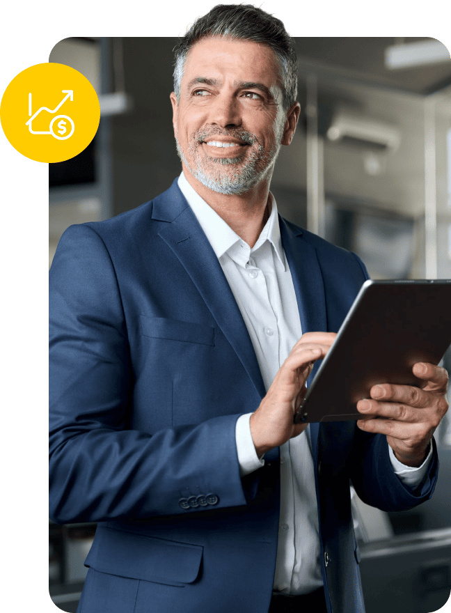 Businessman in a blue suit holding a tablet with a financial growth icon nearby.