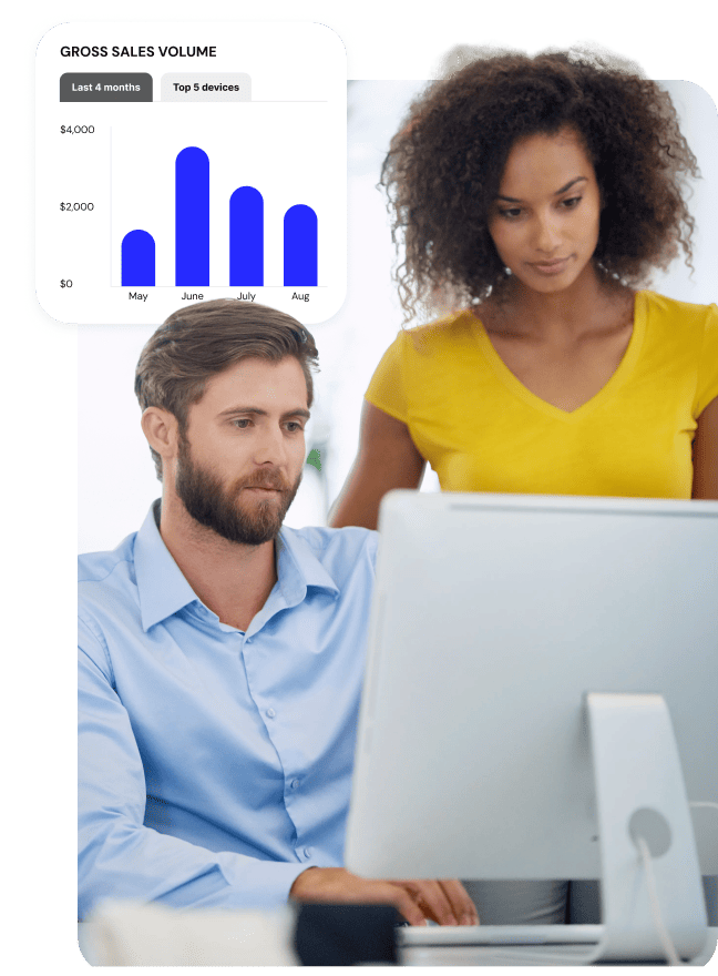 Two professionals reviewing data on a computer next to a monthly sales graph