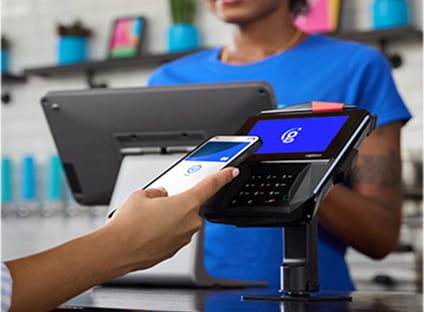 Customer using a smartphone to make a contactless payment at a POS terminal