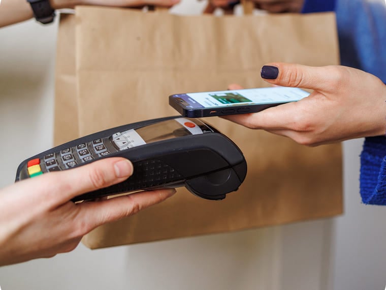 Tapping a smartphone on a credit card reader during a retail purchase