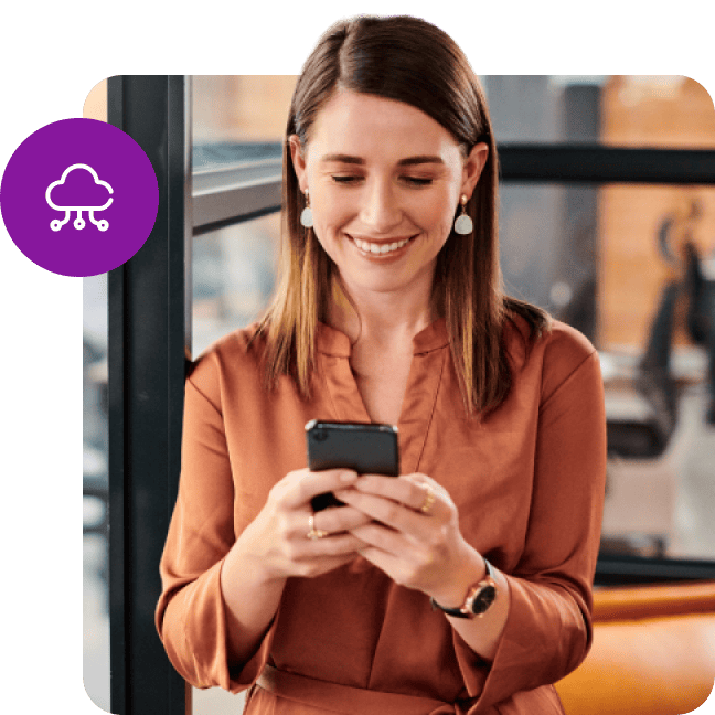 Professional woman in an office smiling while using her mobile phone.