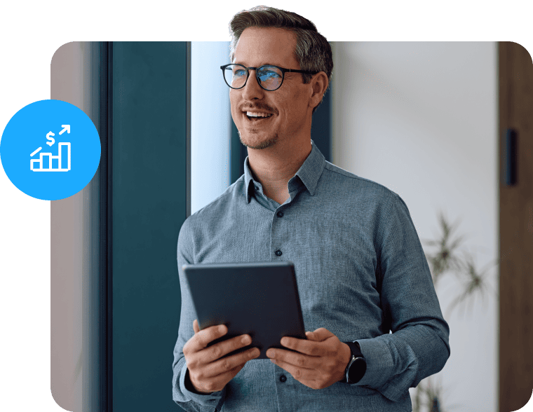 Man holding a tablet near a window with a blue sales growth graphic.