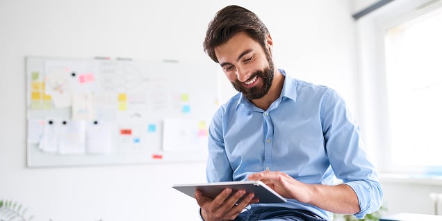 A male professional sitting and working on a tablet device