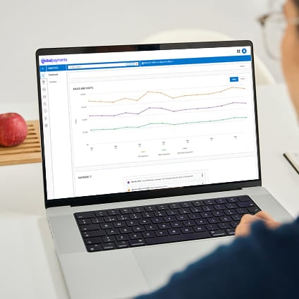 Person viewing an analytics dashboard with line charts on a laptop screen.