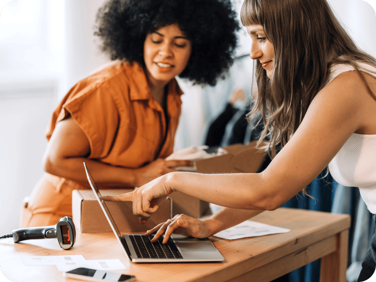 Two people working in a small business set up payment processing solution on laptop.