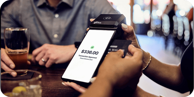Customer uses card to pay for meal on a handheld payment device.