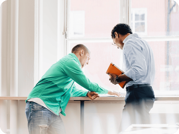 Two people discuss pricing options for payment processing.