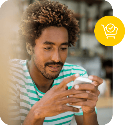 Man using a smartphone with a yellow shopping cart icon overlay.