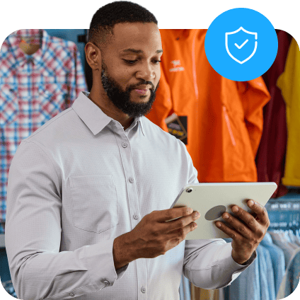 Man using a tablet in a clothing store, with a blue security shield icon overlay