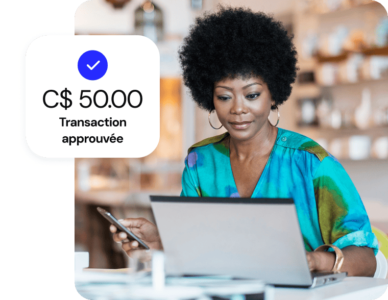 Une femme effectue un achat en ligne sur son ordinateur portable ; une fenêtre numérique confirme la transaction approuvée de 50,00 $.