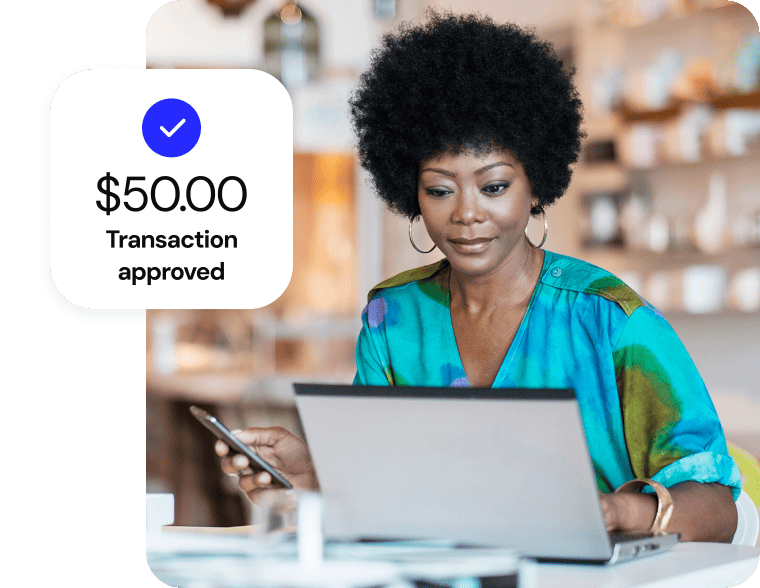 A woman completing an online purchase on her laptop; a digital overlay confirms a $50.00 approved transaction.