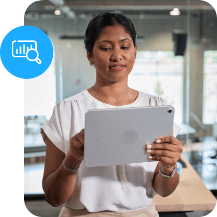 Professional woman analyzing data or reviewing a digital report on a tablet in a bright, contemporary workspace.