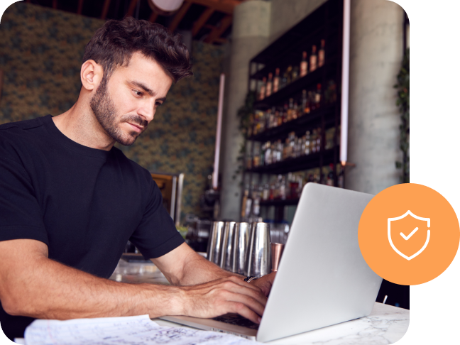 A person working on a laptop with a security shield icon.
