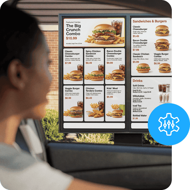 A QSR customer views a digital menu board from her car window in the drive thru.