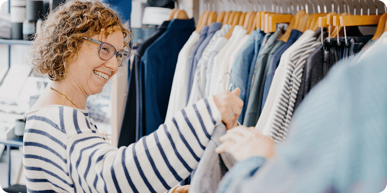 Woman shopping for clothes talks with an associate