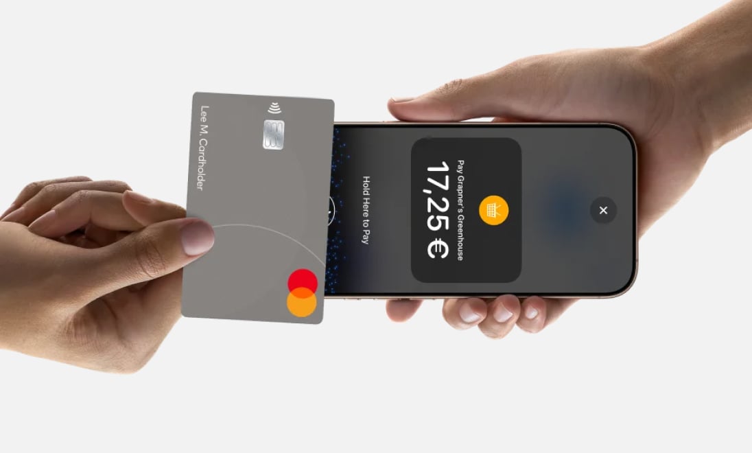 Close up of person making payment with card to iPhone