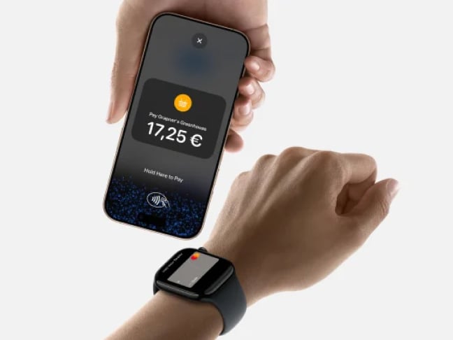 Close up of person making contactless payment with smart watch to handheld POS