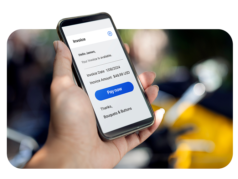 A person holds a phone that displays a screen with a button that says “Pay now.” 